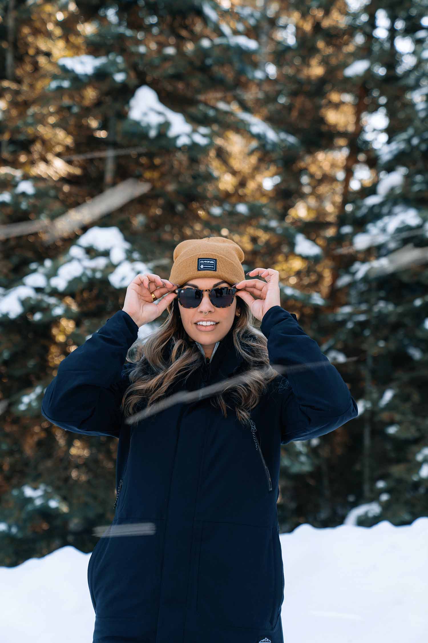 a person wearing sunglasses and hat in snow